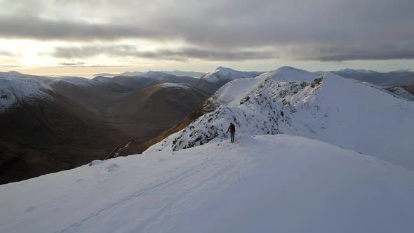 Mountaineer Celebrating Reaching the Summit of a Snowy Mountain alt