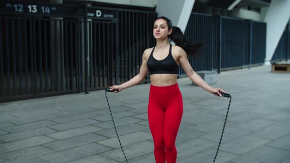 Sporty Woman Training Jump Exercise on Skipping Rope. Closeup Fit Girl Jumping alt