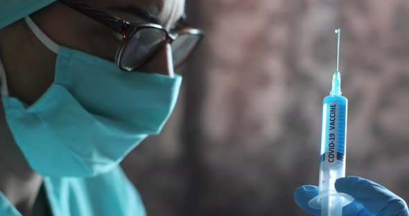 Doctor holding a syringe with the coronavirus COVID-19 vaccine