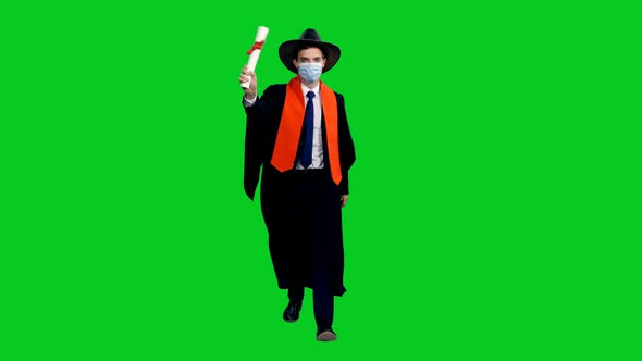 Graduating Student In Cowboy Hat Walking Towards The Camera And Waving Diploma