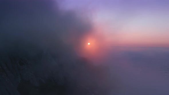 Drone Flying Directly To Gold Sun Through Thick Pink Cloud at Sunset or Sunrise alt