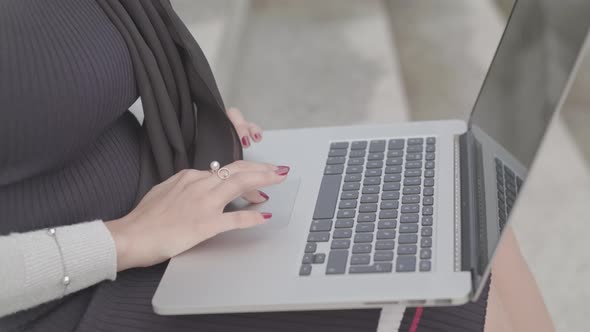 Close Up Shot Of Woman Typing On Laptop Keyboard Whilst Sat Outside - Ungraded alt