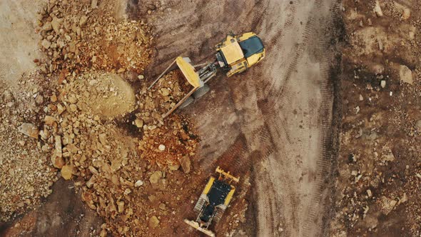 Top View of Yellow Dump Truck Unloads Minerals in the Open Pit alt