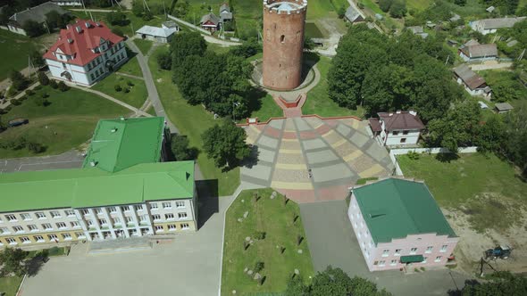 Flight Over A Provincial Town. An Ancient Tower Among The Multi Colored Roofs Of Houses alt