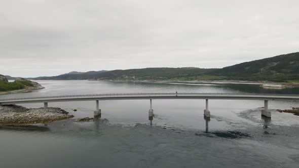 Aerial flyover bridge crossing Fjord near Bodo City during cloudy day in Norway alt