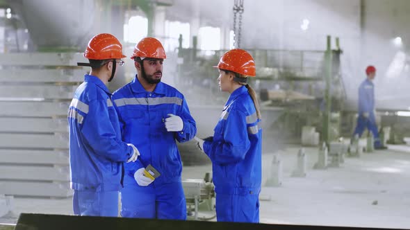 Building engineers discussing methods of work at factory