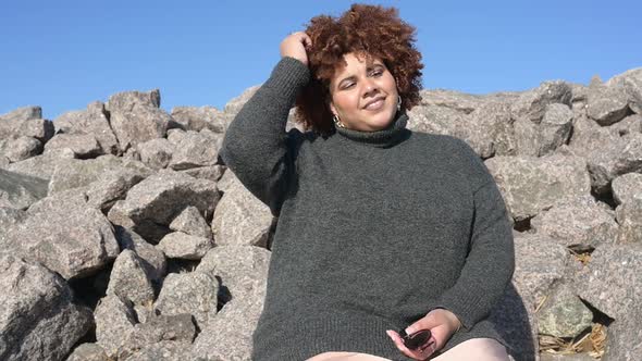 Beautiful Happy Smiling Plus Size African Black Woman Afro Hair in Grey Sweater Outdoor Enjoying