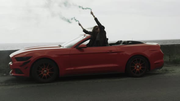 Couple in Red Cabriolet Keep Checkers in Their Hands with Coloured Smoke