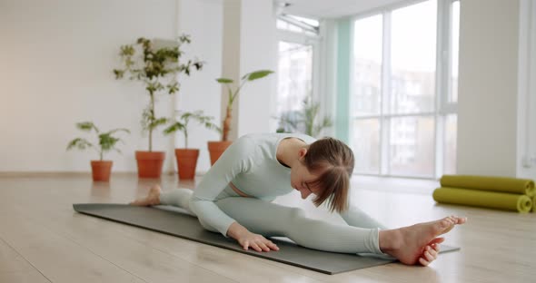 A Beautiful Woman Practices a Spagat Exercises in Bright Studio Anjaneyasana alt