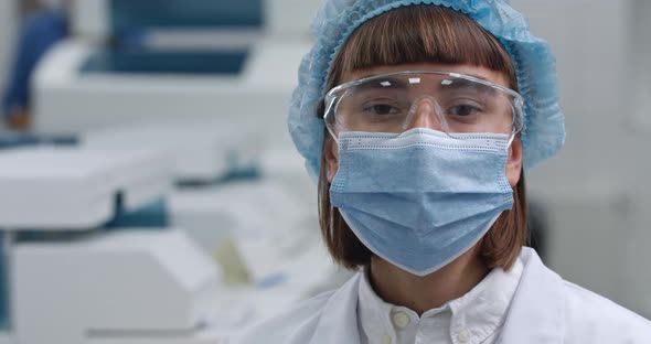 Portrait of Woman in Protective Mask and Googles Turning Head and Looking To Camera alt