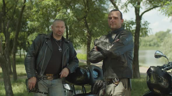 Bikers with Arms Crossed Posing Near Motorbike alt