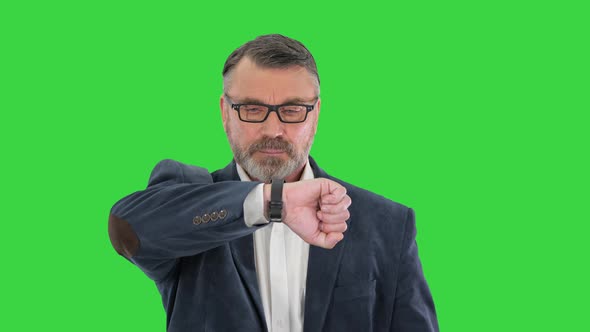 Successful Businessman Walking Fast Looking at Watch on a Green Screen, Chroma Key. alt