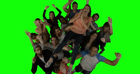 Overhead view of excited executives carrying their colleague alt