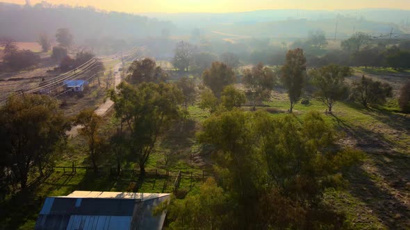 Real-time drone footage of a misty sunny morning over Clarksville, California, USA, showing green gr alt