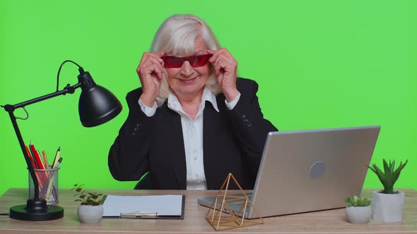 Senior Stylish Businesswoman Wears Red Sunglasses Looking at Camera Blinking Winking Eyes Flirting alt