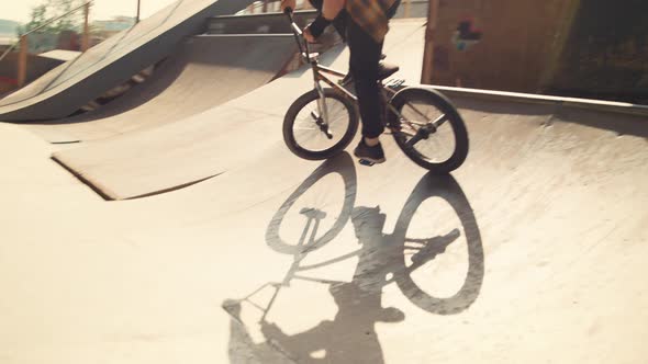 Sporty Biker Performing Tricks on Bmx Bicycle in Urban City Skate Park alt