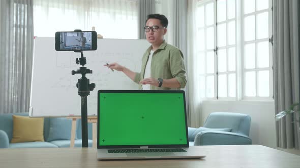 Male Teacher With Green Screen Laptop Shoots Video By Smartphone Camera While Teaching Math At Home alt