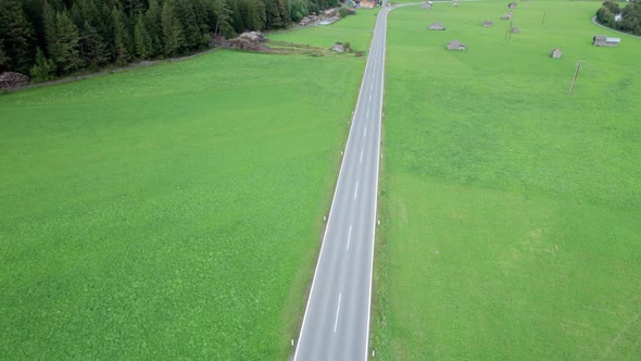 Empty Asphalt Road in Austria Between Green Fields in the Alps Aerial View alt