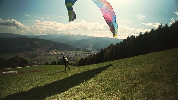 Paraglider Takes Off From a Hill