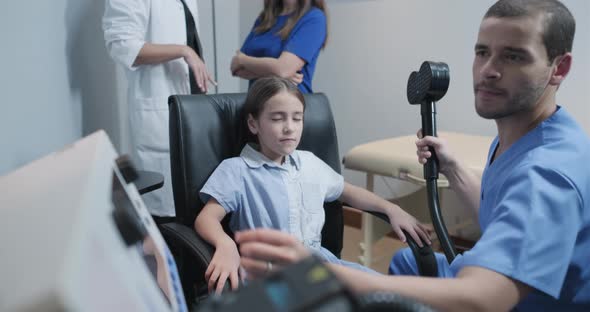 Medial Team in Hospital Treating Little Autistic Girl Using TMS
