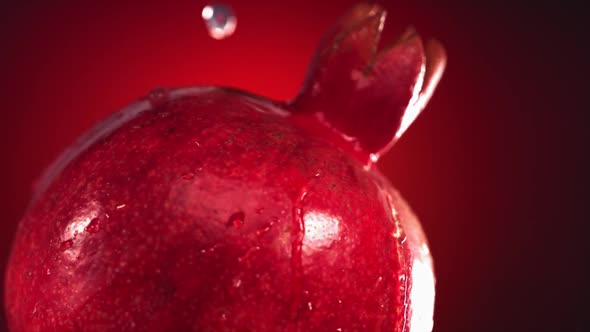 Super Slow Motion Water Drips on Rotating Pomegranate alt