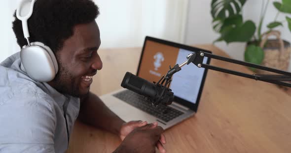 Young african man doing podcast using computer laptop at home - Technology trend concept alt