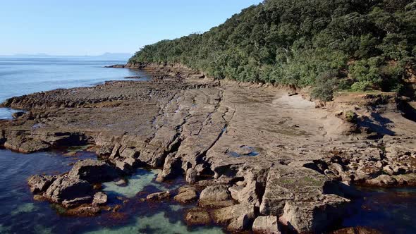 Aerial Approach Towards Chiseled And Eroded Rock Formations Of Goat Island Shore On A Bright Sunny D alt