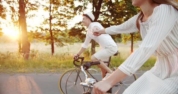 Lovely Couple Riding Bicycles and Holding Hands