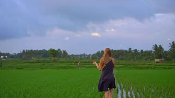 Slowmotion Shot of a Young Woman with a Kite Walking Through a Big Beautiful Rice Field alt