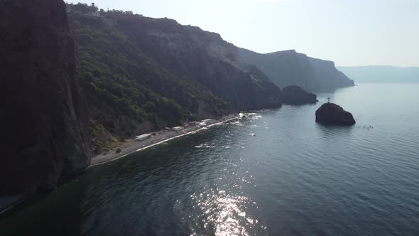 Aerial View From Above on Calm Azure Sea and Volcanic Rocky Shores alt