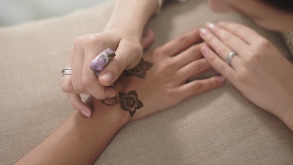 Close Up Shot of a Woman's Hands, Who Has a Mehendi on Her Wrist and Fingers alt