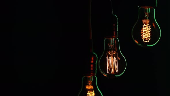 Silhouettes of glowing vintage lamps in the dark copy space.