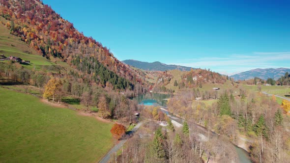 Drone Flight Over Klammsee Reservoir In Autumn Under Blue Sky alt