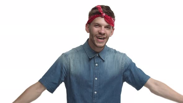 Cheerful Handsome Man with Red Headband Over Forehead Showing Thumbsup in Approval Praise you and