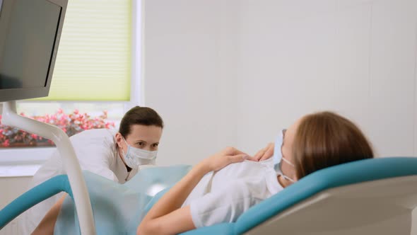 Female Gynecologist in Medical Unifrom Examining Patient alt