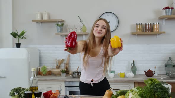 Girl Recommending Eating Raw Vegetable Food. Showing Peppers in Hands. Weight Loss and Diet Concept alt