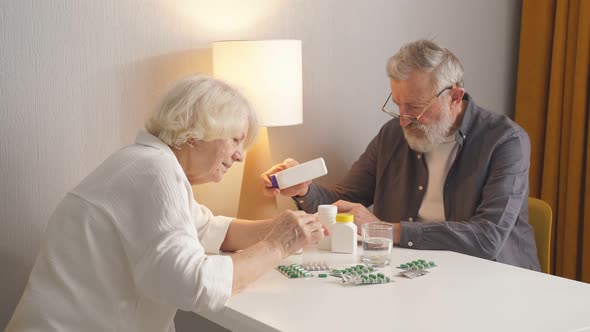 Two Elderly Man and Woman Reading Indications and Instructions for Use of Drug