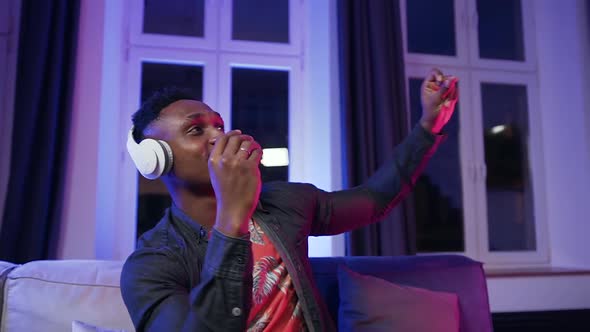 30-Aged Dark-Skinned Guy in Headphones Dancing with Hands Under Cool Disco Music alt