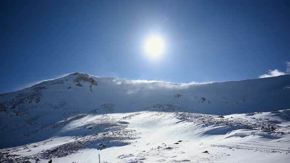 Snow blowing off of Colorado Rocky Mountain peaks during the day, static alt