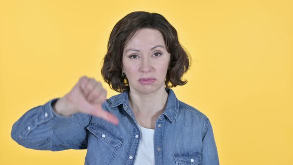 Thumbs Down By Old Woman, Yellow Background  alt