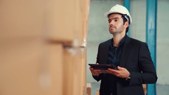 Factory Manager Using Tablet Computer in Warehouse or Factory alt