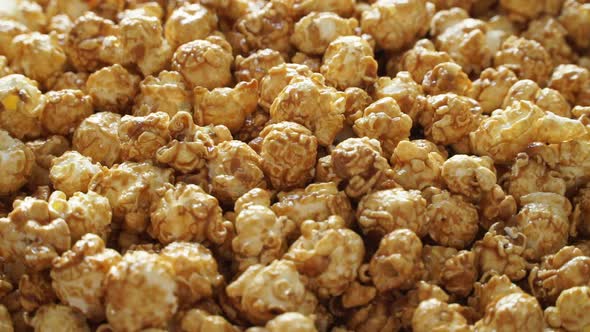 Close Up of Golden Sweet Caramel Popcorn Rotates on Board