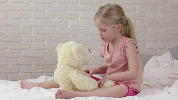 Adorable Happy Little Child Girl Playing with Teddy Bear