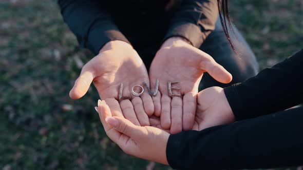 The Perfect Landscape of Hands Holding the Word Love Made of Twigs in Their Palms and Instead of the alt