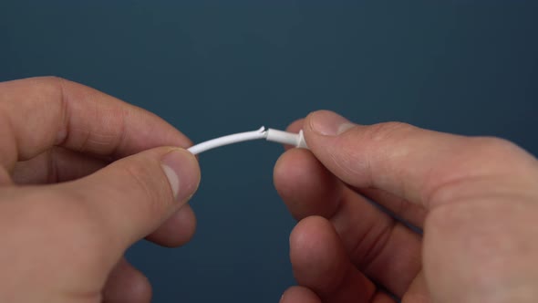 Torn Phone Charger Cable Closeup. A Man Holds a Torn Wire in His Hands. Wire Wear alt