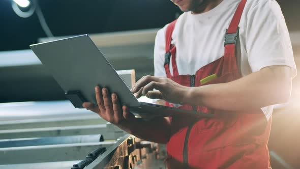 Industrial Conveyor and a Male Engineer Holding a Laptop alt