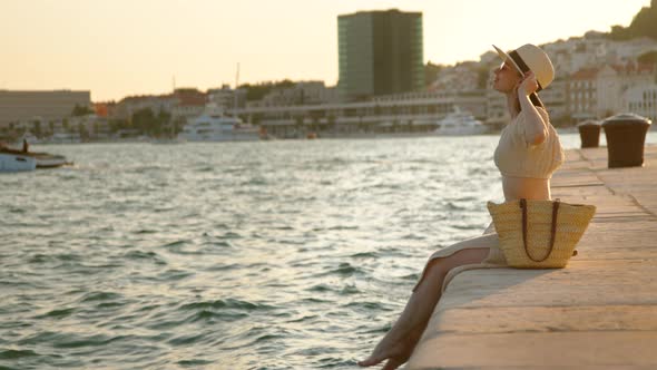 Happy woman with bare feet on the pier in summer. Split, Croatia alt