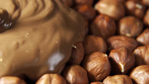 Pouring Hot Melted Chocolate and Almond Nuts Texture Close Up alt