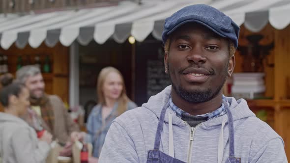 Happy street cafe's owner standing outside