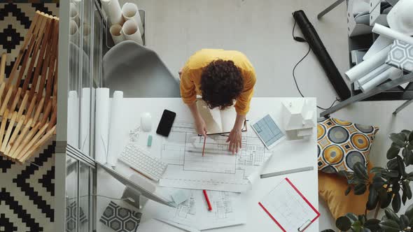 Top Down of Female Architect Drawing Floor Plan and Posing for Camera alt